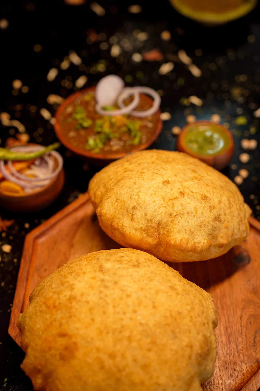 Two golden bhature on a wooden board