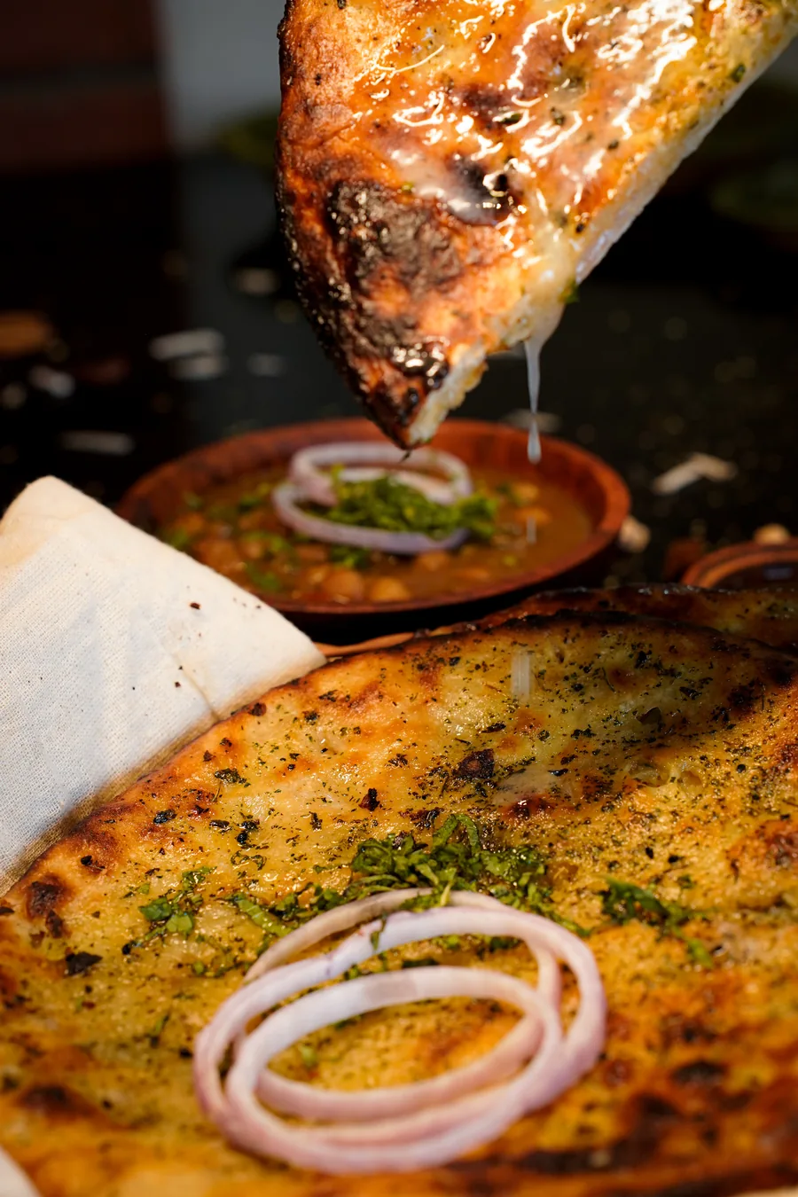 Hot Amritsari kulcha above a bowl of chole