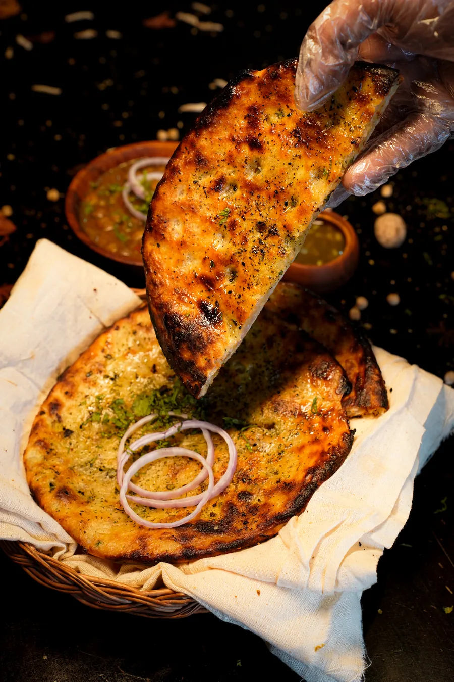 A kulcha held up above the basket